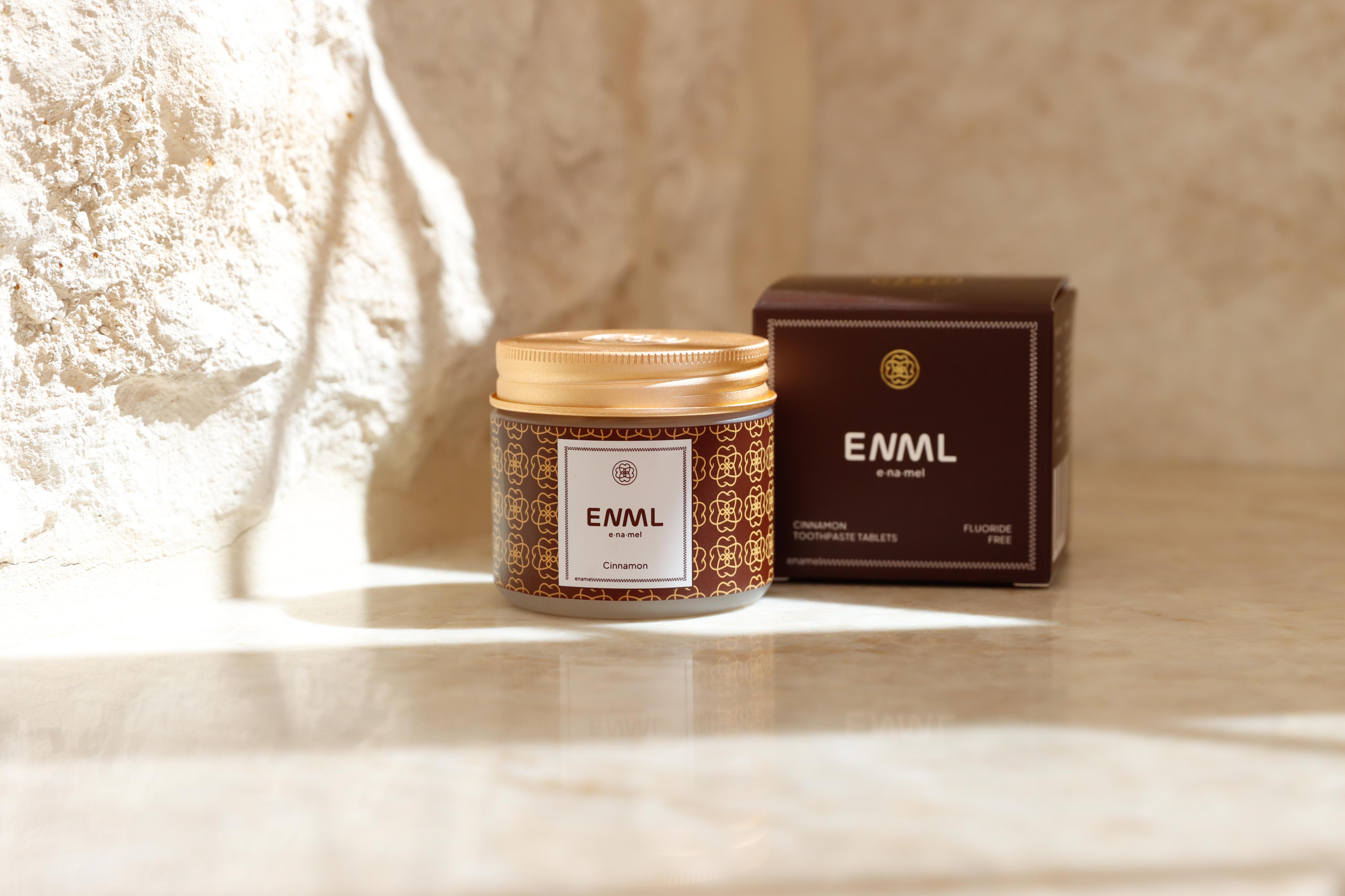 ENML Cinnamon Toothpaste Tablets jar and retail box on marble - fluoride-free cinnamon flavor dentist-designed oral care