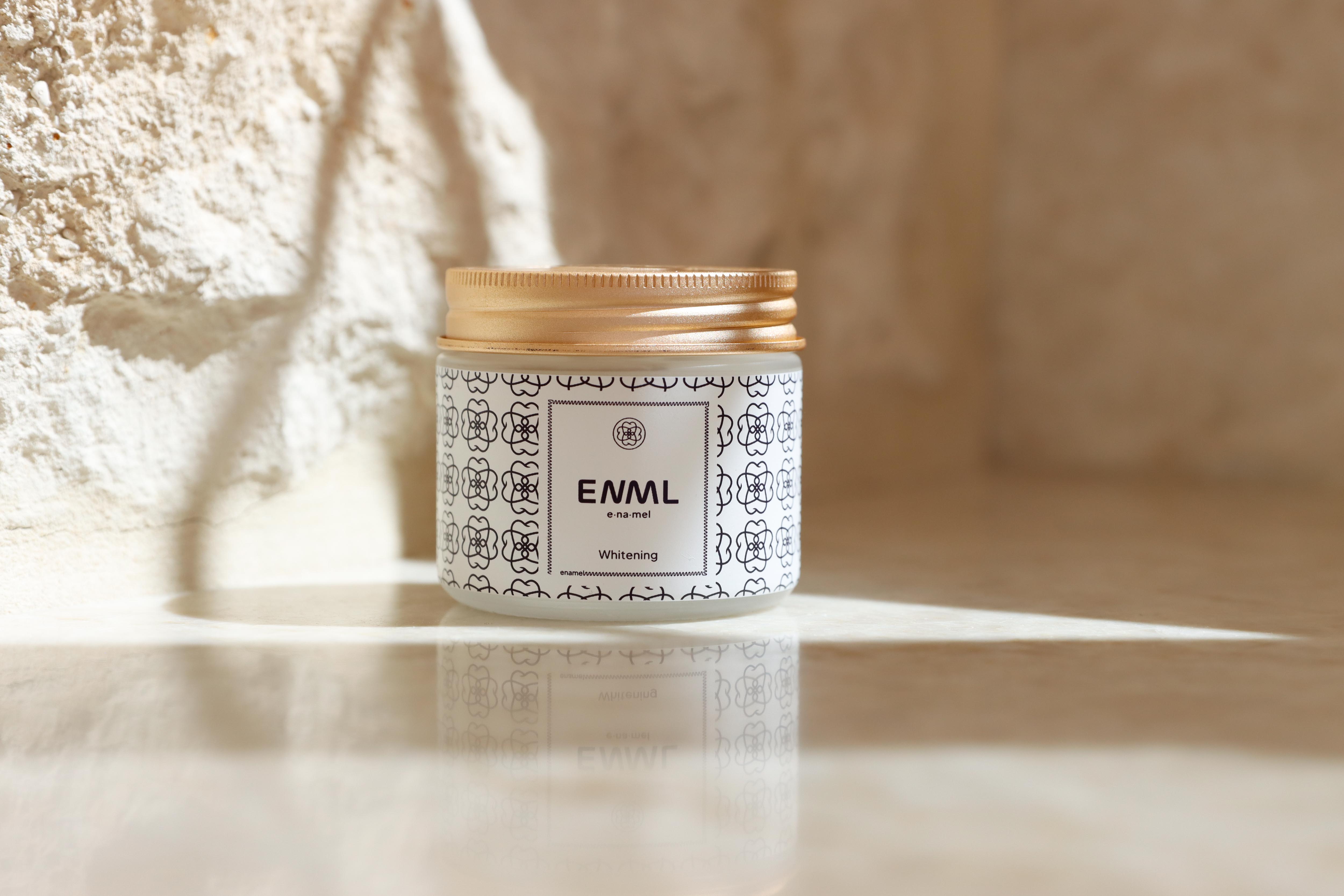 ENML Whitening Toothpaste Tablets jar on marble surface - fluoride-free hydroxyapatite whitening tablets with gold lid